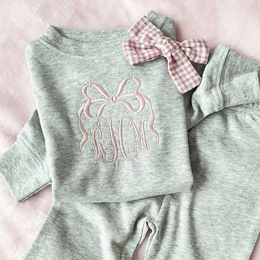 heather gray baby set with long sleeve top and flare leggings, featuring a personalized bow monogram embroidered design in powder pink on the center chest of the top.