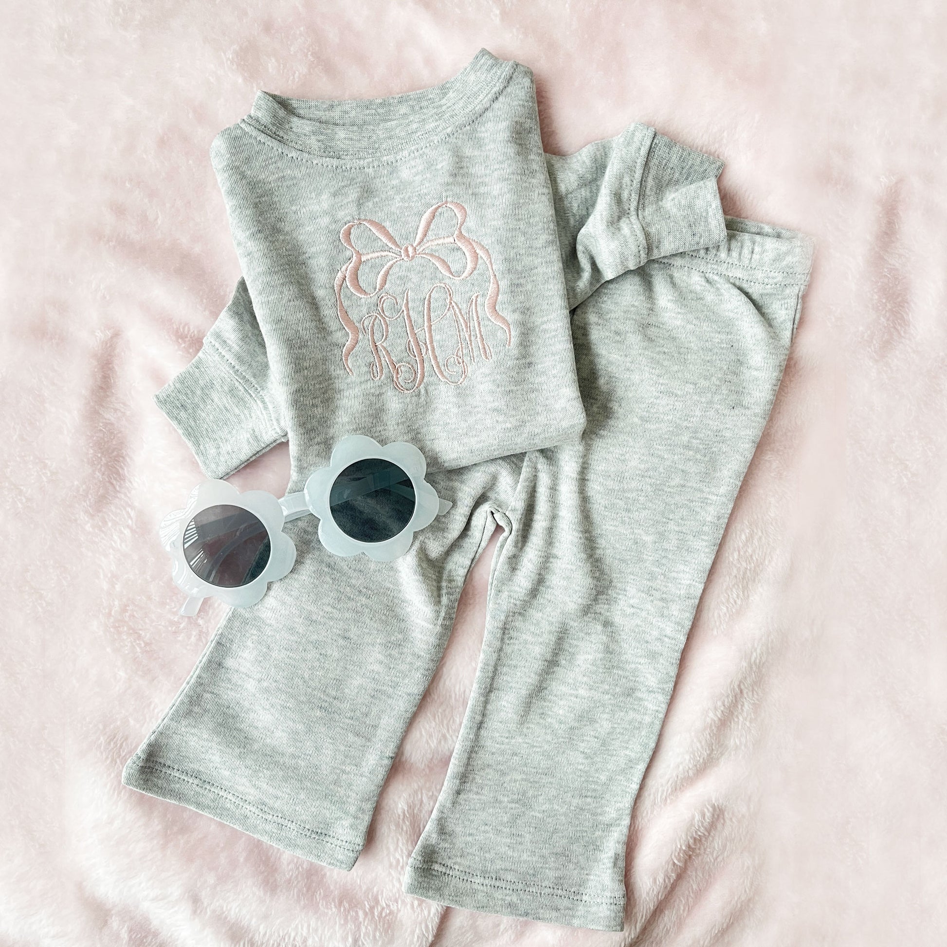 heather gray baby set with long sleeve top and flare leggings, featuring a personalized bow monogram embroidered design in powder pink on the center chest of the top.