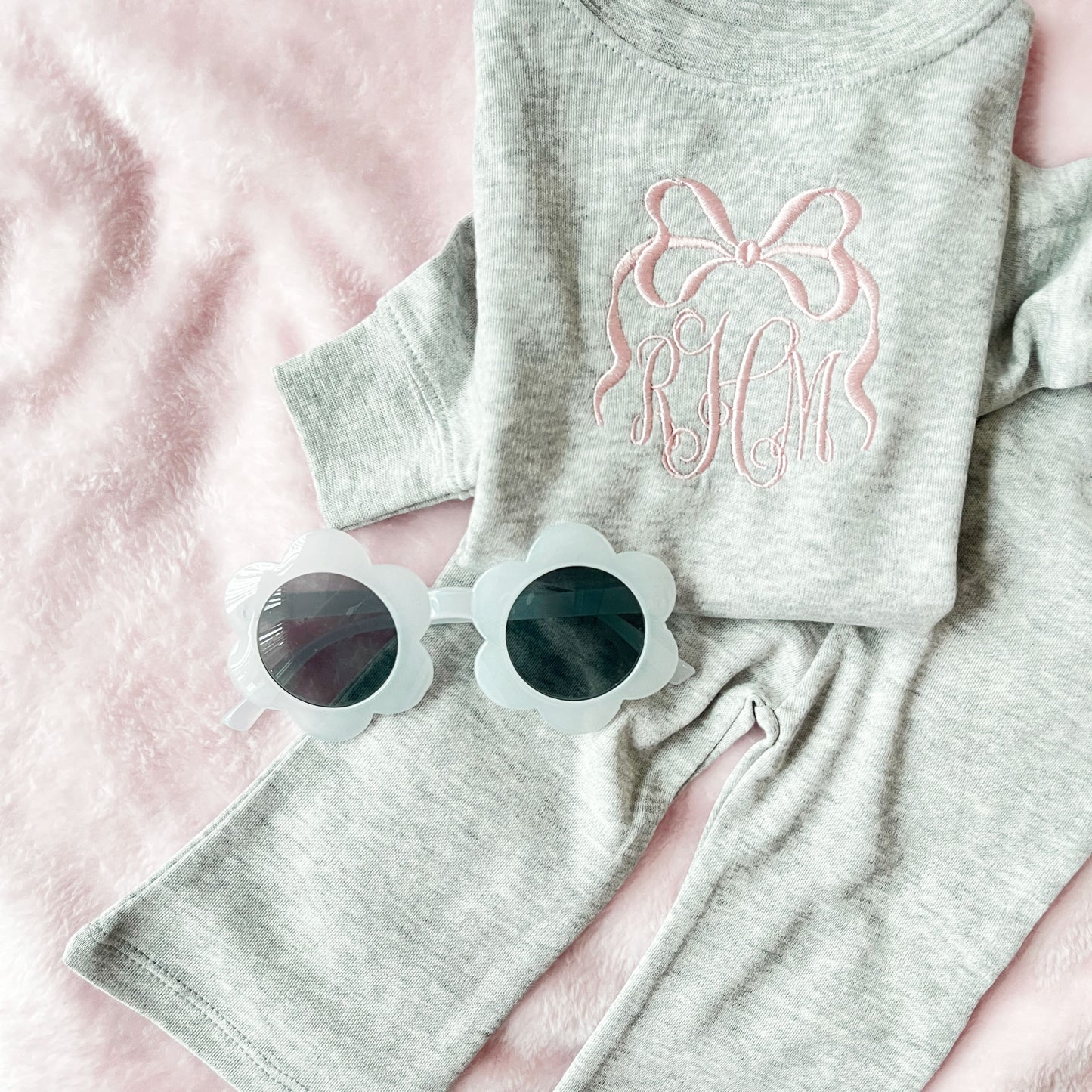 heather gray baby set with long sleeve top and flare leggings, featuring a personalized bow monogram embroidered design in powder pink on the center chest of the top.