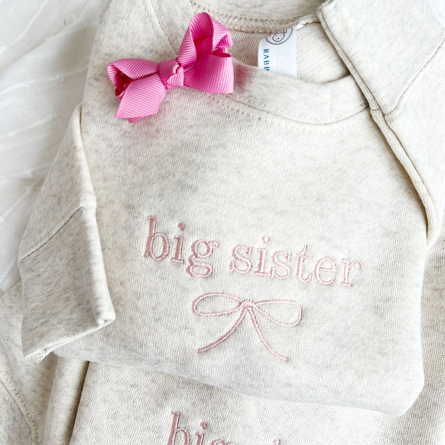 heather oatmeal crewneck sweatshirts with custom big sister bow embroidery in powder pink thread