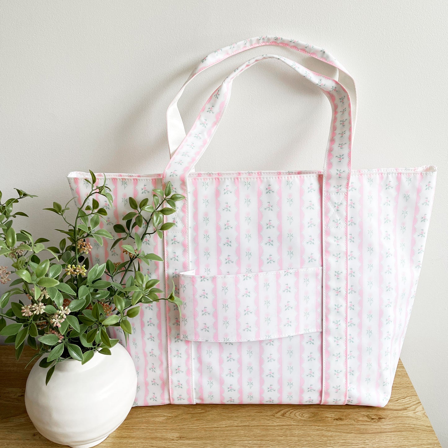 back of floral pink jumbo tote featuring a trolley passthrough pocket