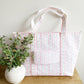 back of floral pink jumbo tote featuring a trolley passthrough pocket