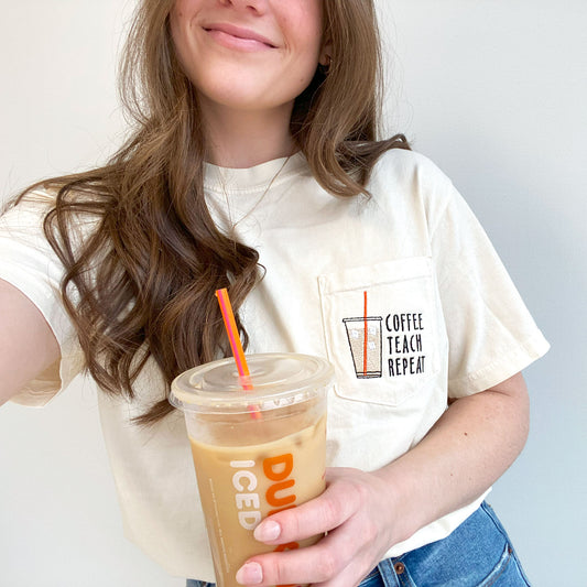 young woman wearing an ivory comfort colors pocket t-shirt with iced coffee and coffee teach repeat embroidered design on the pocket  