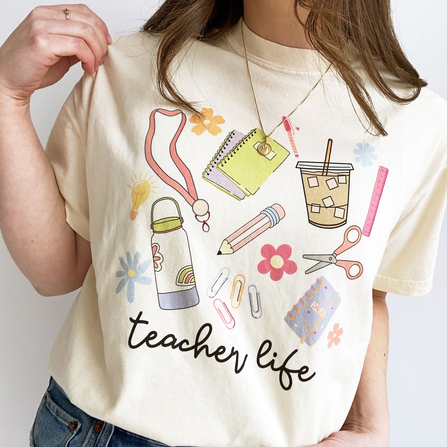 woman wearing a cute t-shirt with a colorful, playful school supplies teacher life print