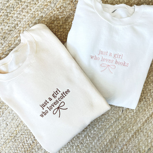 white crewneck sweatshirt with just a girl who loves books and a dainty bow embroidered on the center chest and a sweet cream crew with just a girl who loves coffee and a dainty bow embroidered on the center chest