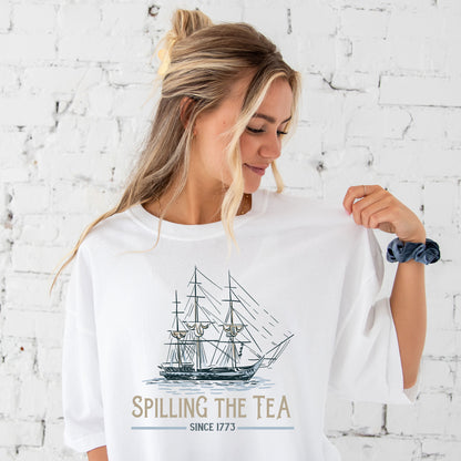 girl wearing an oversized white tee with a fun spilling the tea printed design