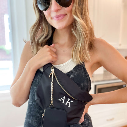 woman wearing a crossbody nylon belt bag with a custom initial embroidery and clipped on wallet