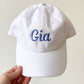 youth white baseball hat with gia embroidered in purple thread