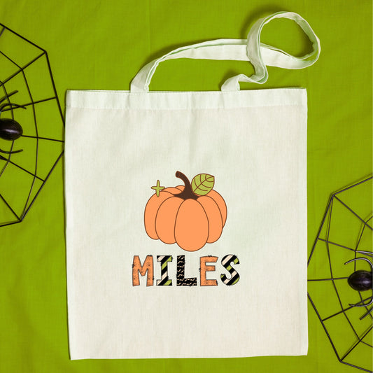 natural canvas trick or treat tote bag with custom pumpkin and name with mixed halloween patterned font print