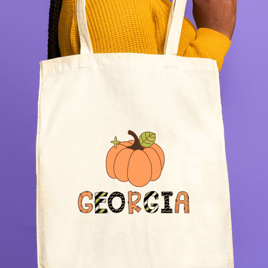 natural canvas trick or treat tote bag with custom pumpkin and name with mixed halloween patterned font print