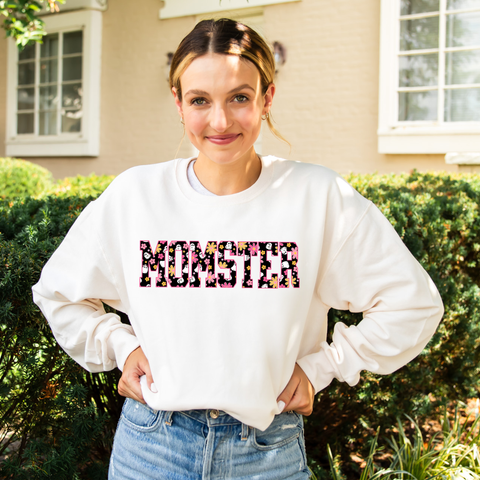 woman wearing a oversized crewneck sweatshirt featuring a MOMSTER DTG print with a groovy daisy/ghost pattern
