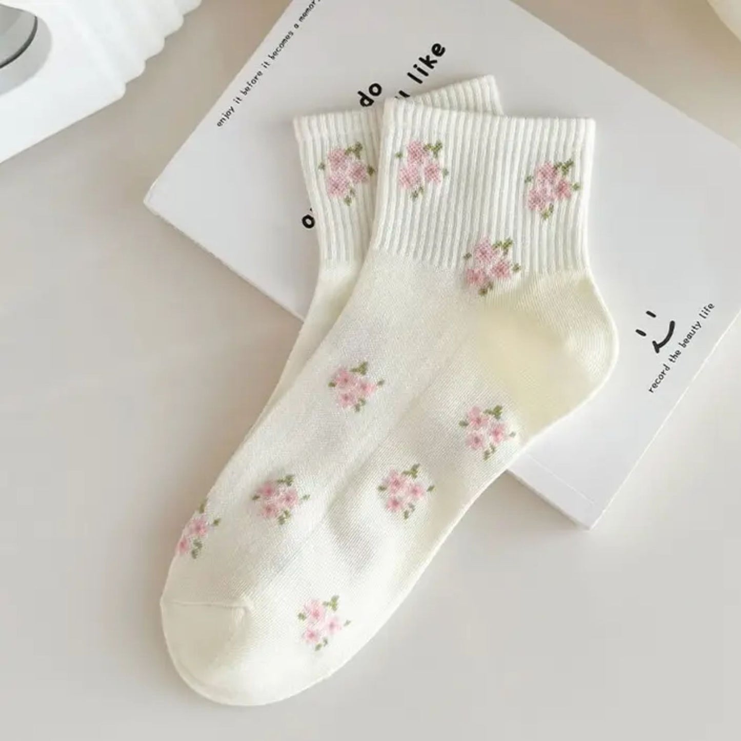 White socks with floral patterns on a light surface