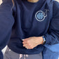 close up of nurse wearing a navy pullover sweatshirt with a custom stethoscope and monogram designed embroidered on the left chest