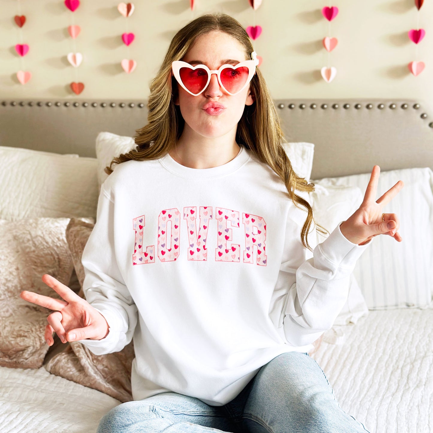 young woman modeling a white crewneck sweatshirt with printed lover design filled with valentine's hearts
