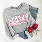 athletic crewneck sweatshirt with mama printed across the chest in a watercolor heart pattern design