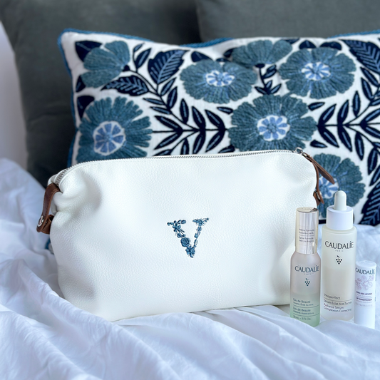 white dopp kit featuring french blue embroidered floral V in the center