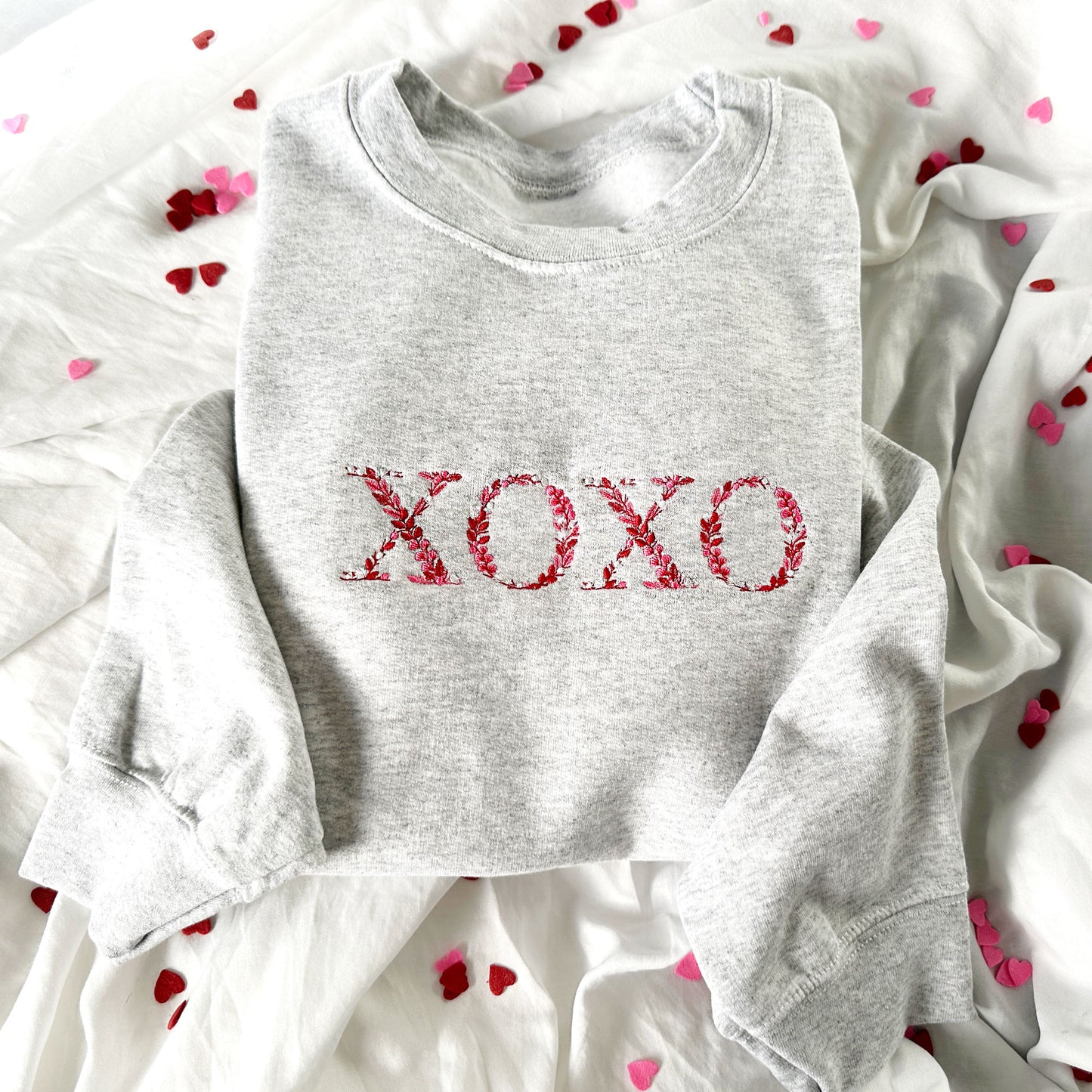 Ash crewneck sweatshirt with xoxo floral embroidered design in red, pink, and white threads