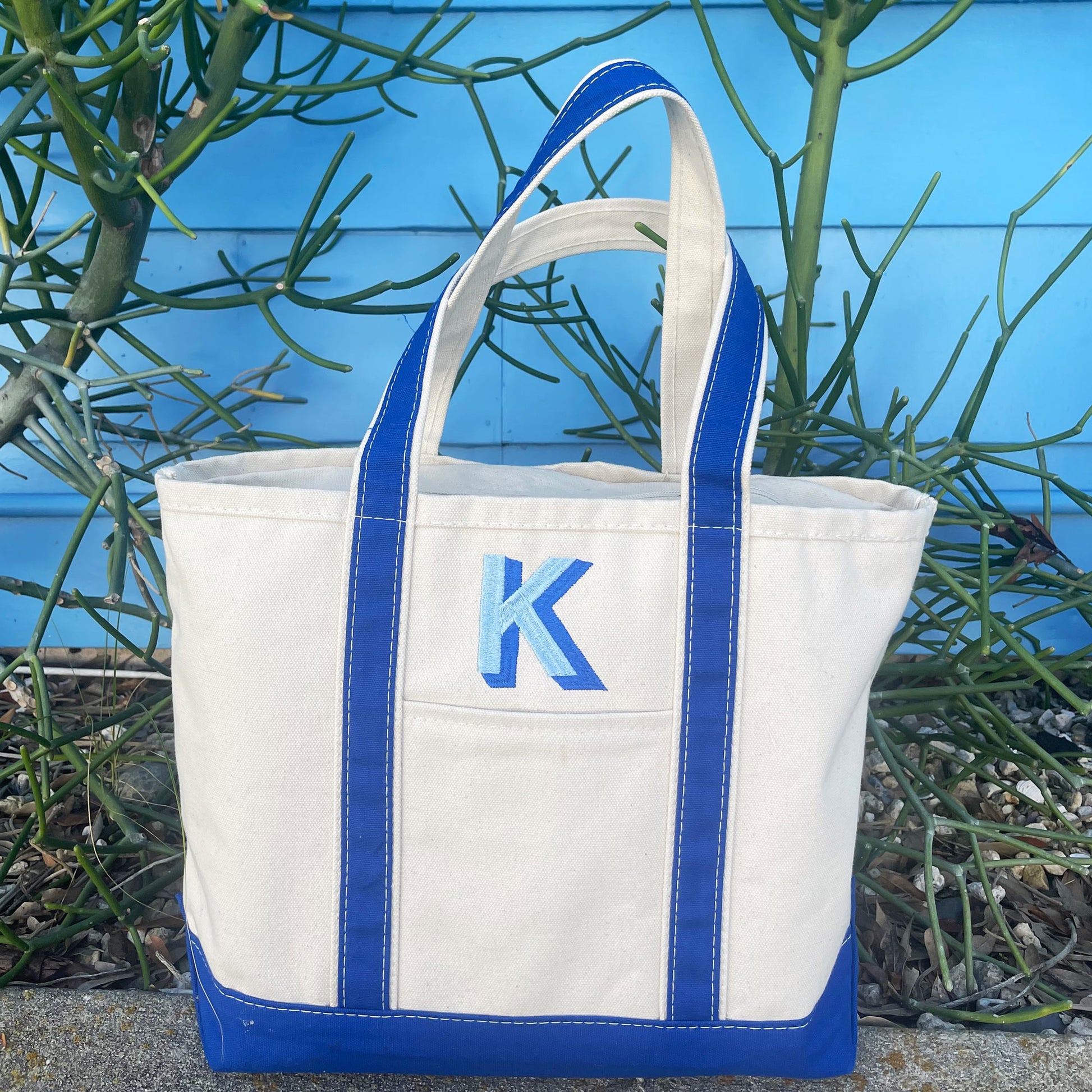 Medium canvas boat tote with a royal blue trim and light blue and royal blue embroidered shadow block initial