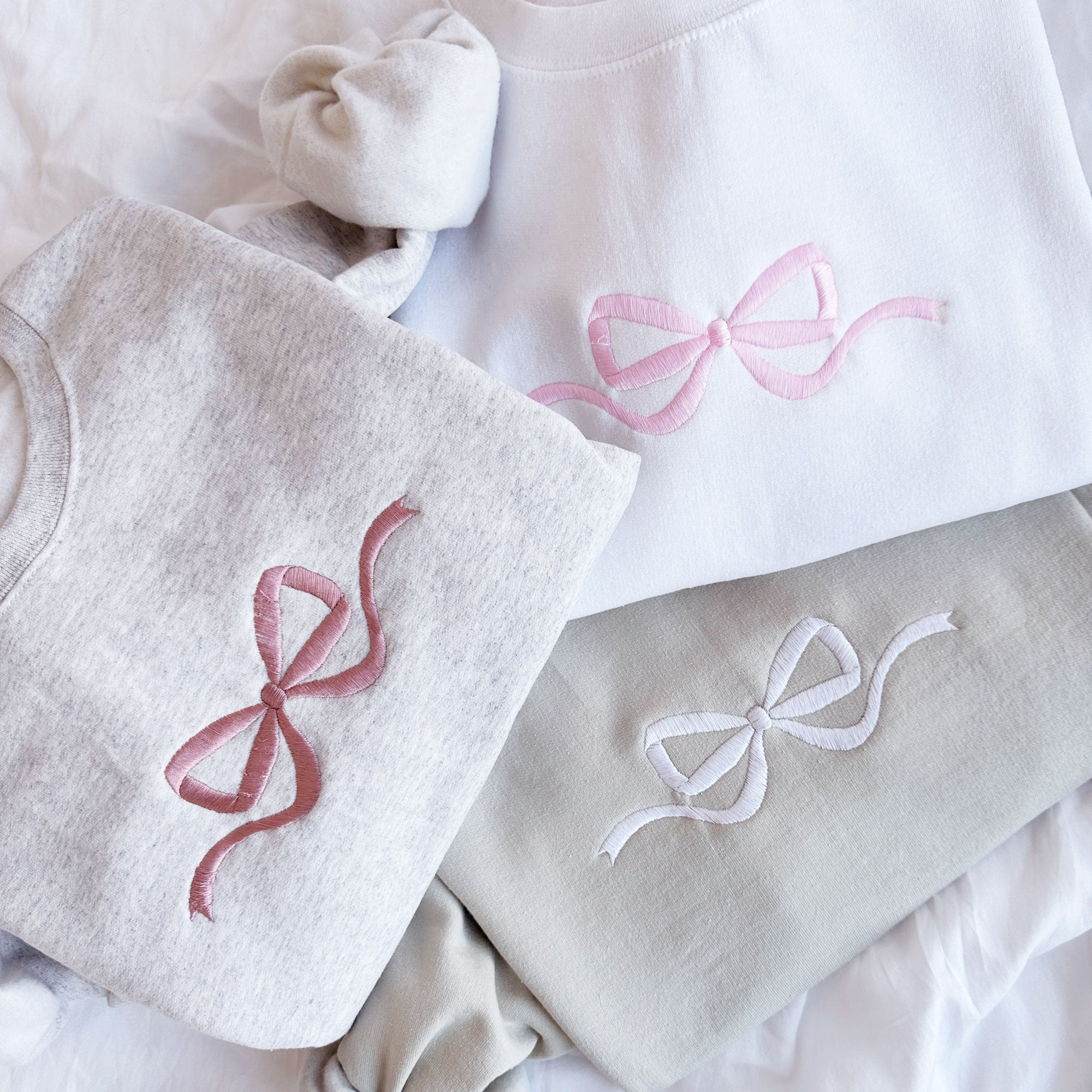 heather oat sweatshirt with mauve bow embroidered, white sweatshirt with baby pink bow, sand sweatshirt with white bow