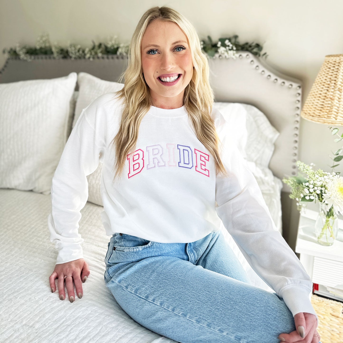 bride wearing a custom crewneck sweatshirt with BRIDE embroidered across the chest in an athletic block font