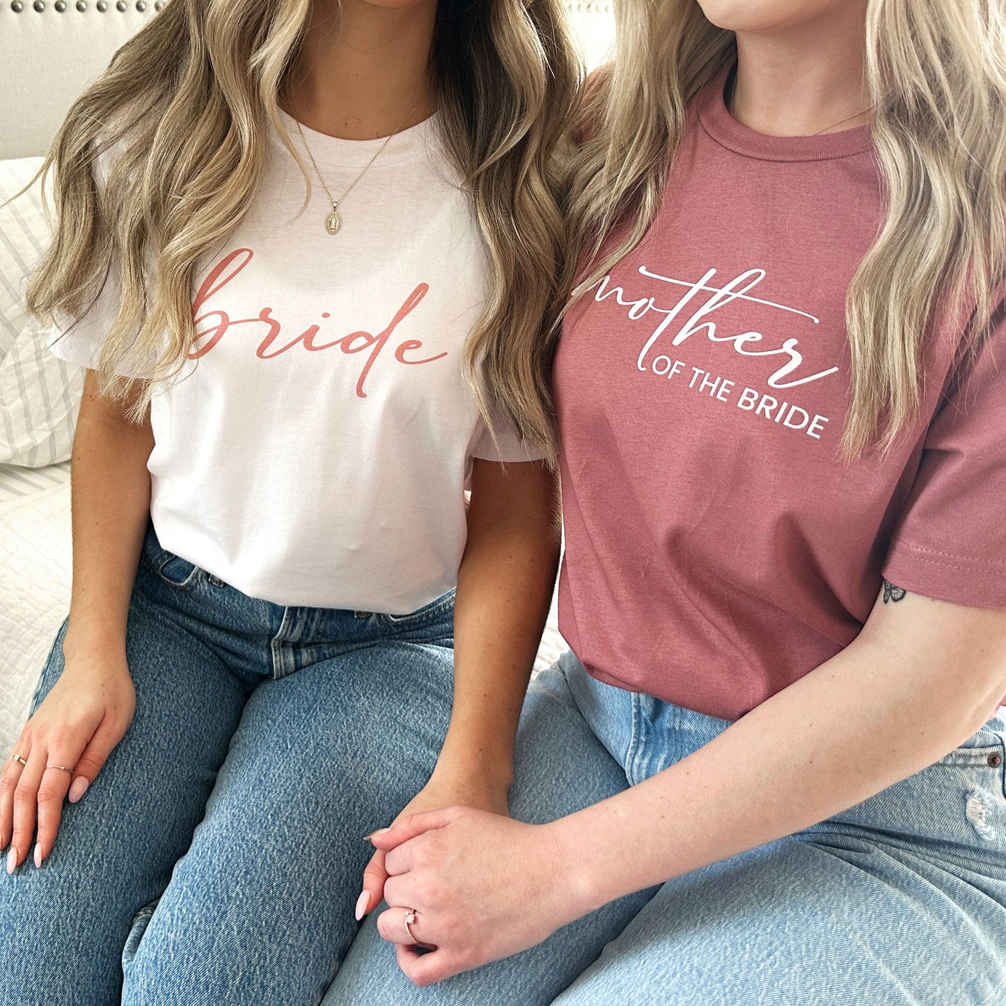 2 ladies waring bella and canvas crewneck tees one in white with bride printed and onw in mauve with mother of the bride printed across the chest