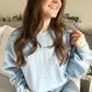light blue crewneck sweatshirt with embroidered bride in white thread