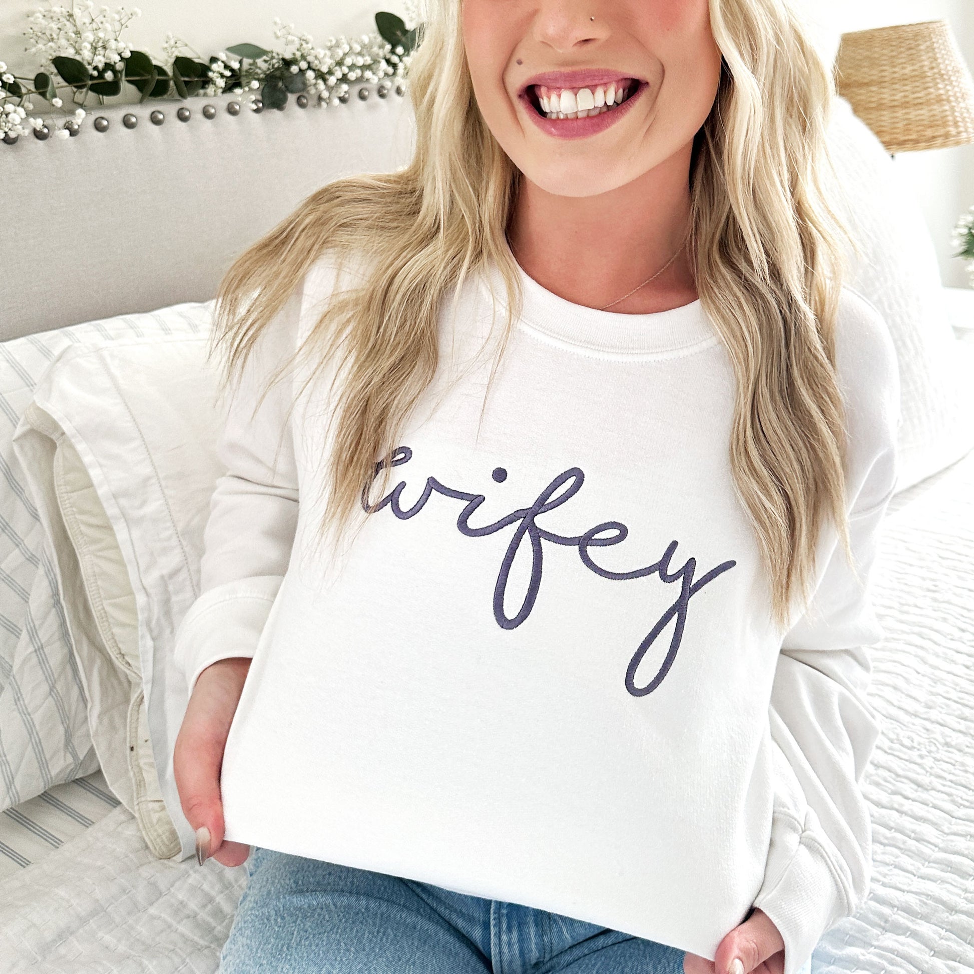 white crewneck sweartshirt featuring wifey embroidered in a script font and in smoky orchid thread
