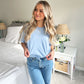 young woman styling a baby blue crewneck tee with minimal all caps wifey embroidered across the chest in white thread