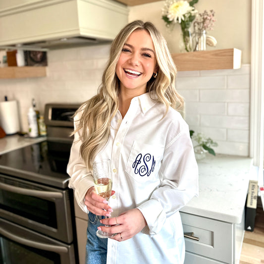 young woman wearing a white button down with monogram embroidered on the pocket