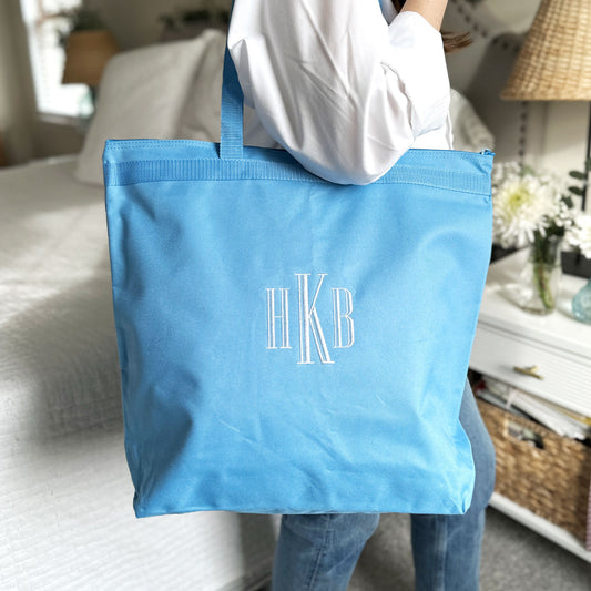 light blue tote bag with monogram embroidered in white thread