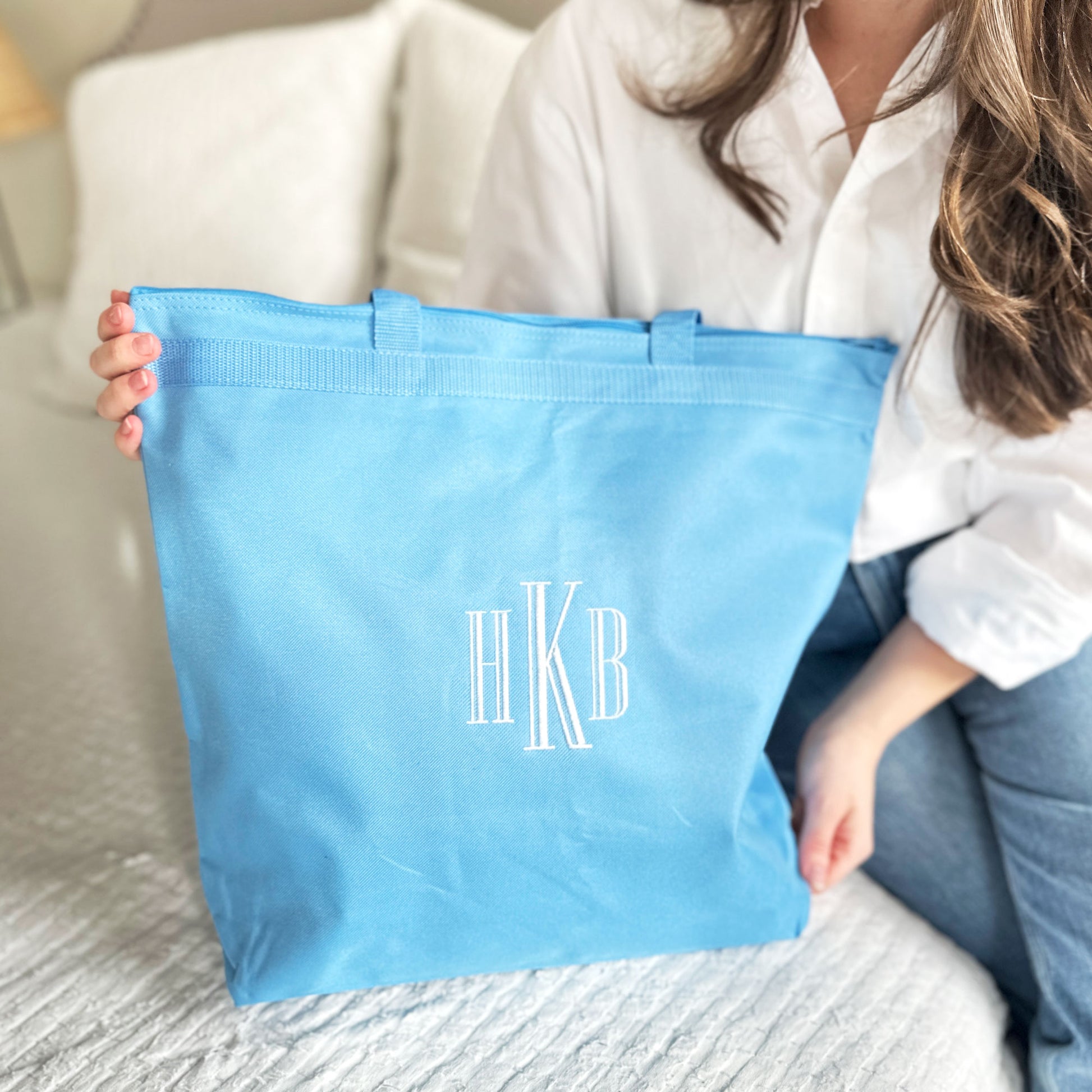 light blue tote bag with monogram embroidered in white thread