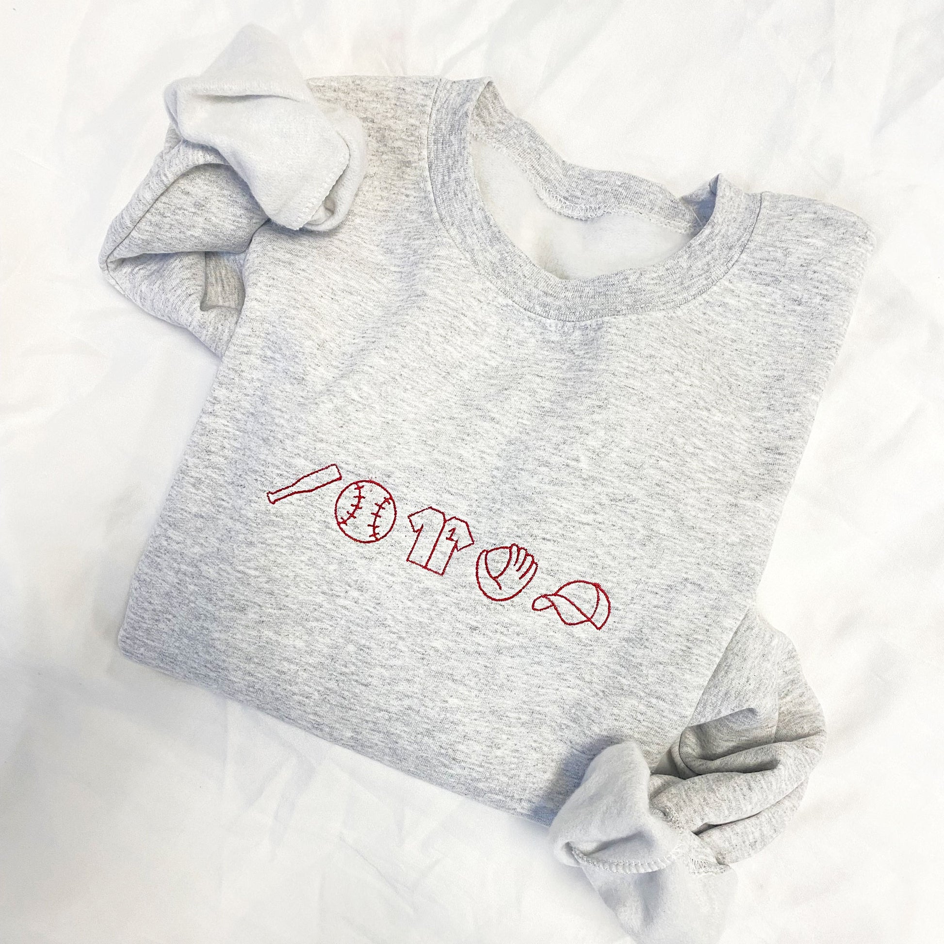 Ash crewneck sweatshirt with red embroidered baseball icons across the chest.
