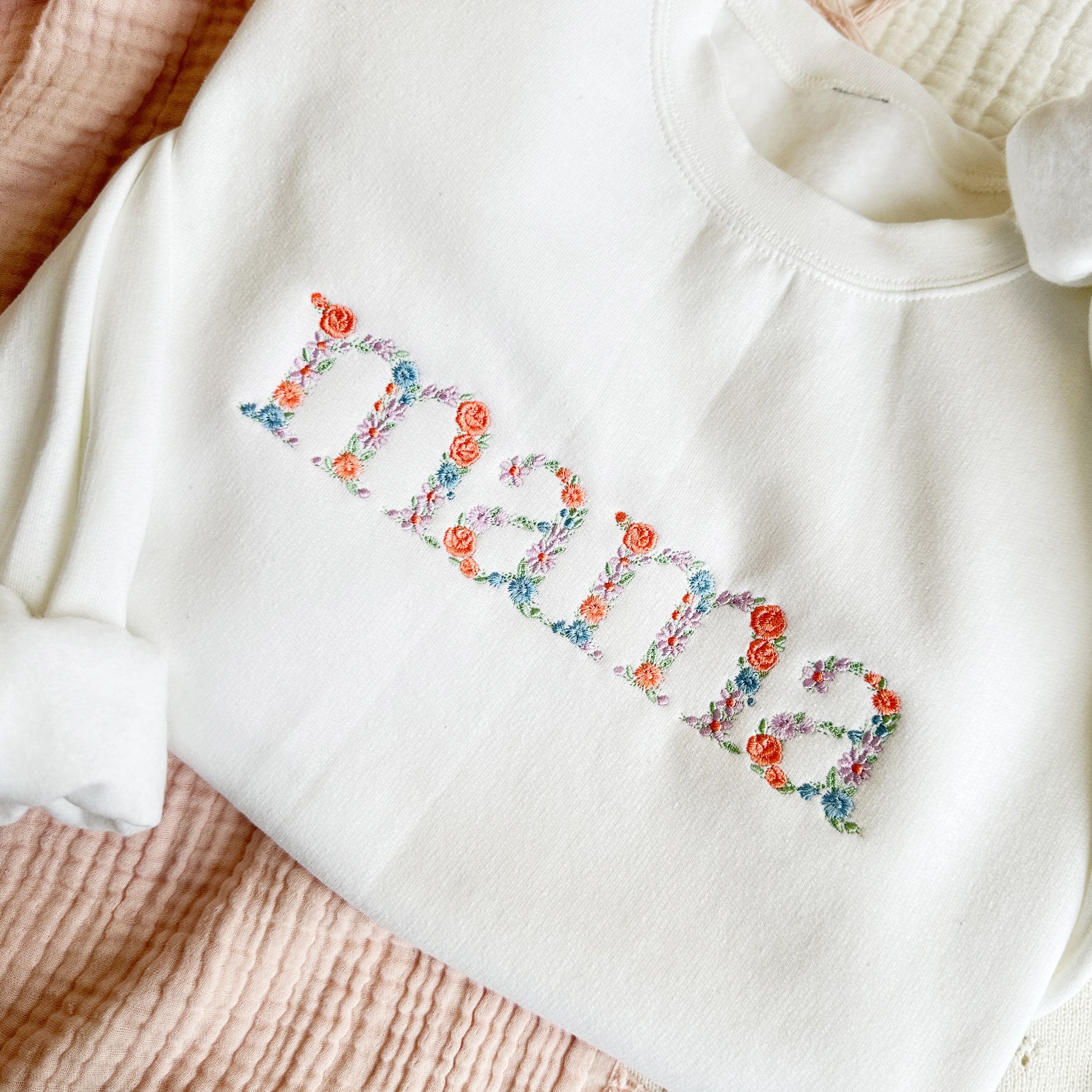 pring floral embroidered mama on a white crewneck sweatshirt