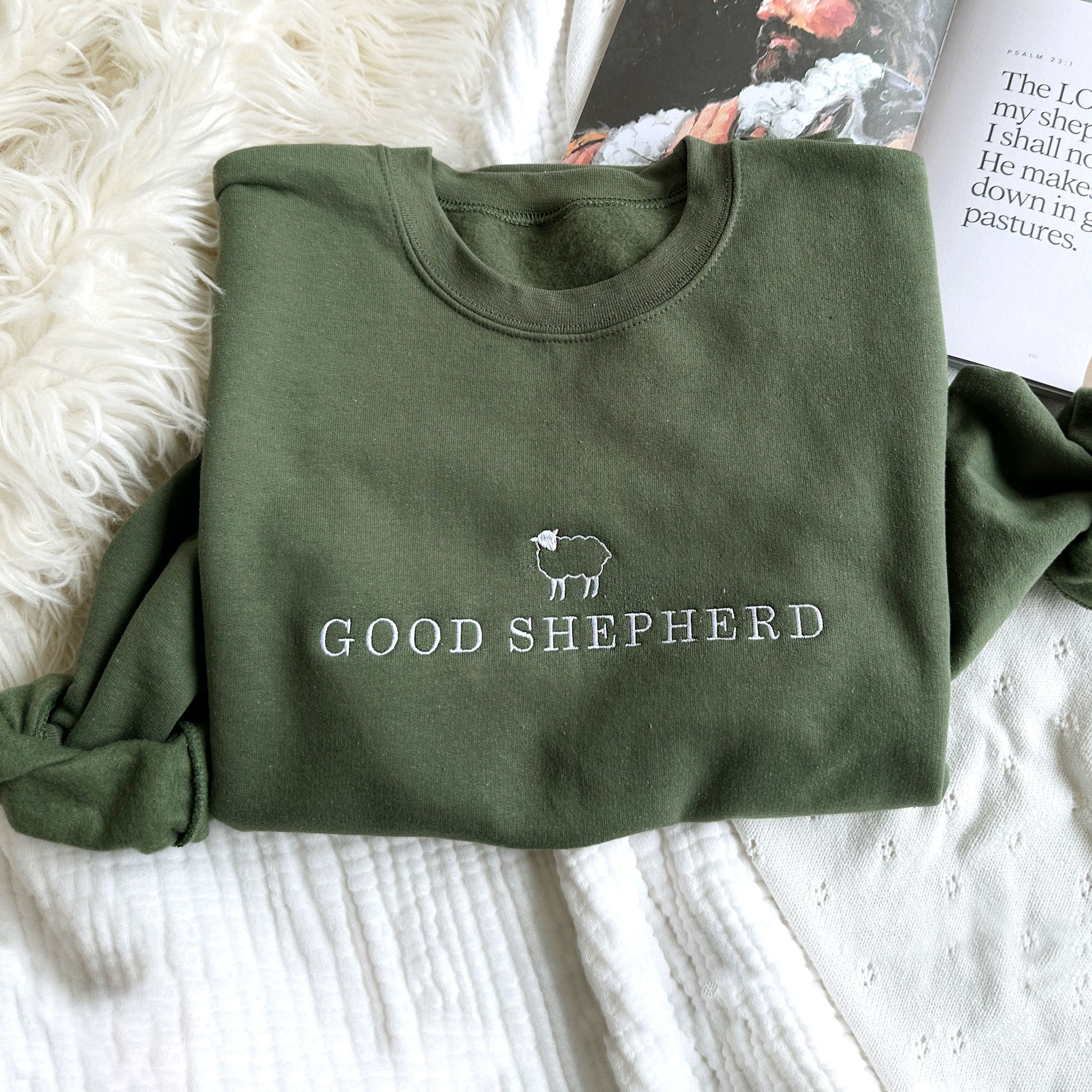 Olive green crewneck swatshirt with good shepherd and little sheep design embroidered across the chest in white