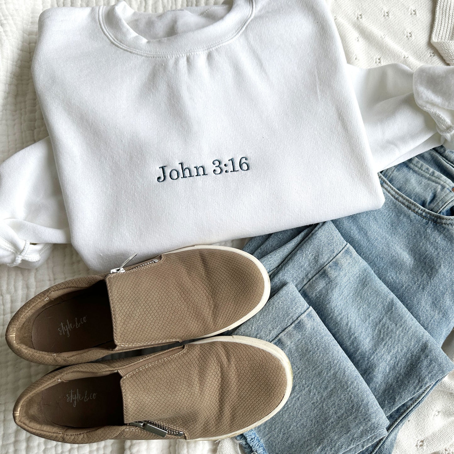 white crewneck sweatshirt with bible verse John 3:16 embroidered in french blue thread and sneakers