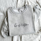 Ash crewneck sweatshirt with embroidered he is risen in a script font and gray thread