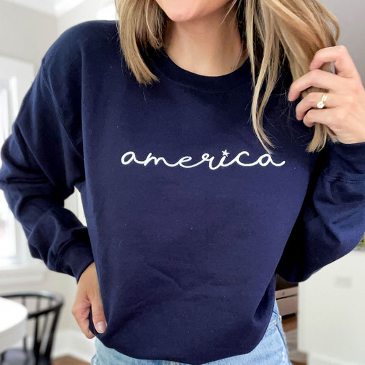 close up of embroidered navy blue crewneck with an america design