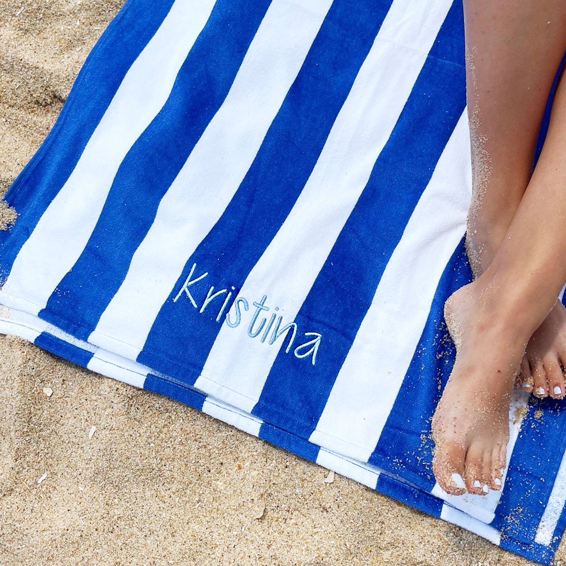 Royal blue and white stripped each towel on the beach with embroidered full name Kristina on powder blue thread