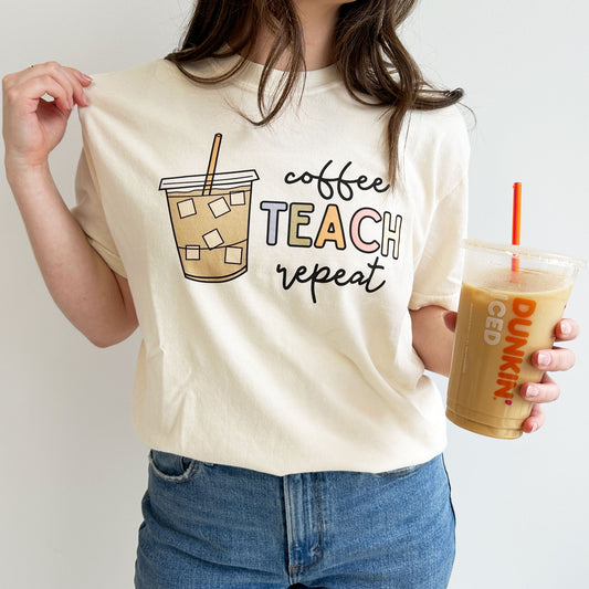 woman wearing an ivory crewneck t-shirt with a playful iced coffee teach repeat design