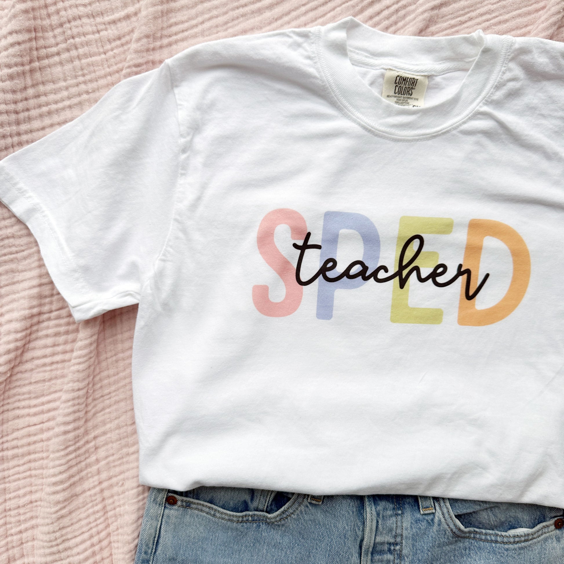 white crewneck tee with a colorful SPED teacher printed design on the front