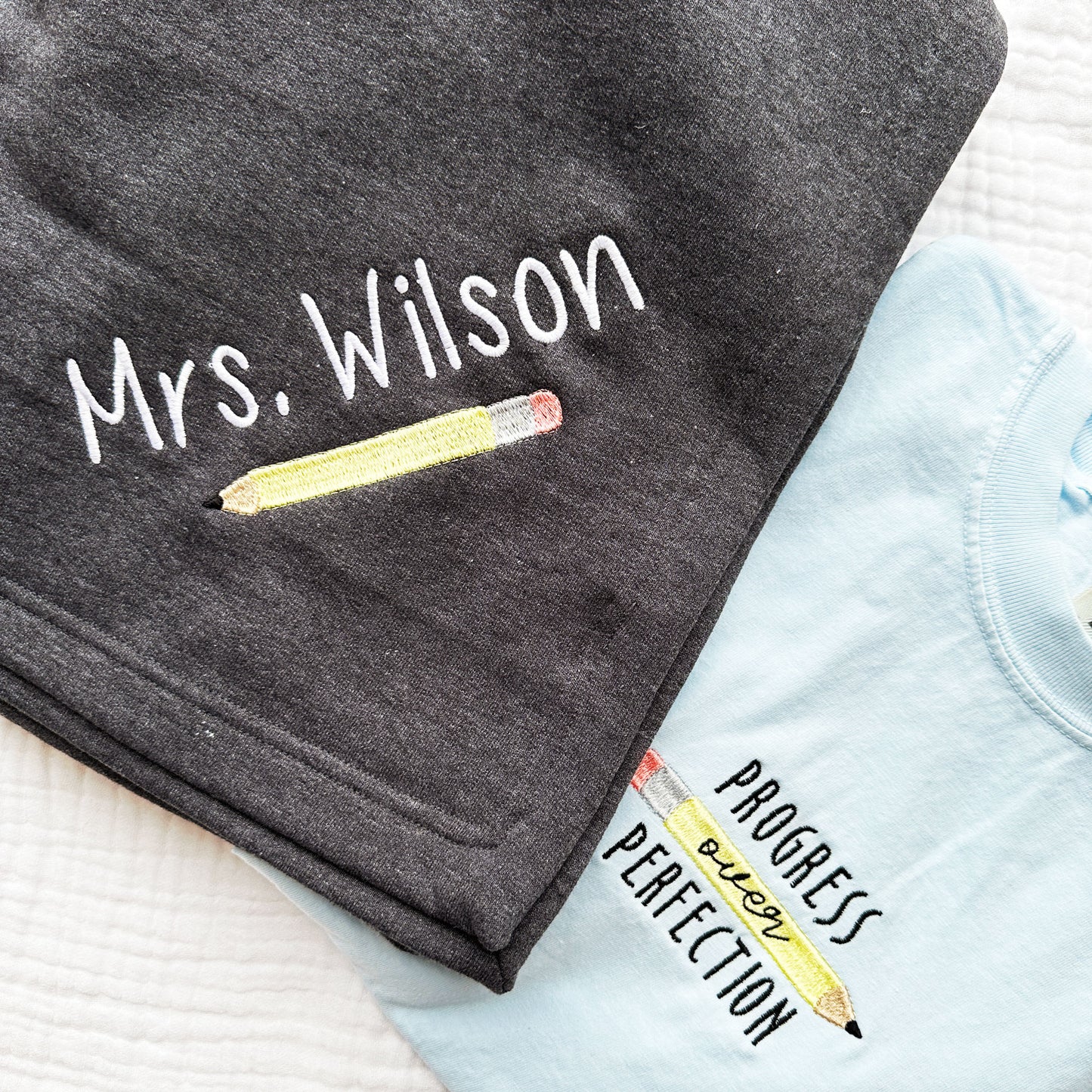 cute personalized sweatshirt blanket with name and yellow pencil embroidered design paired with a chambray blue comfort colors t-shirt with a progress not perfection embroidered design