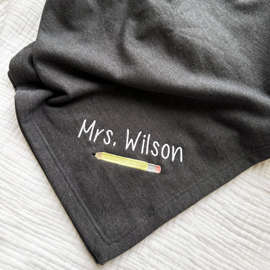 heather charcoal stadium sweatshirt blanket with a cute personalized teacher name and no. 2 pencil design embroidered on the corner