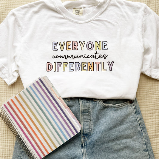 cute teacher outfit featuring jeans and a white comfort colors t-shirt with everyone communicates differently printed design on the center chest