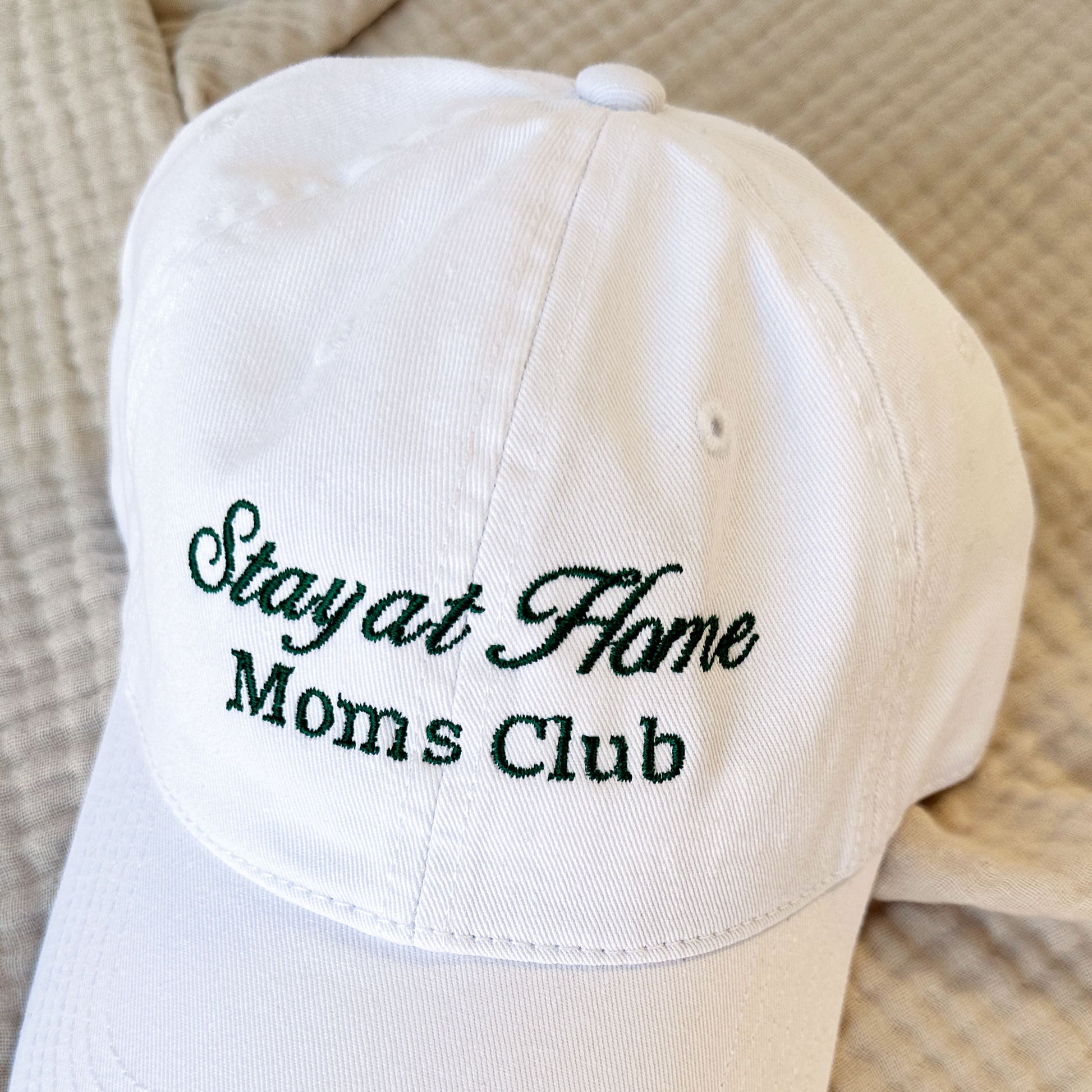 white hat with stay at home moms club embroidered on the front