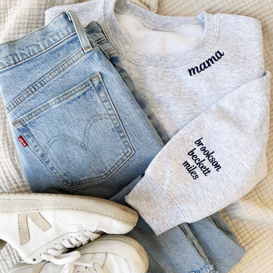 ash grey crewneck with mama embroidered on the neckline and children's names embroidered on the sleeve