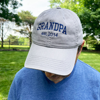 man wearing a grey basball cap with a custom grandpa embroidered design with an est date as well