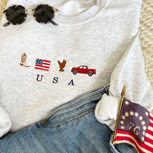 ASH GREY CREWNECK SWEATSHIRT WITH EMBROIDERED COWBOY BOOT, AMERICAN FLAG, EAGLE, TRUCK AND USA EMBROIDERED DESIGN ACROSS THE CENTER CHEST