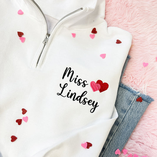 white quarter zip sweatshirt with personalized name and mini heart embroidery