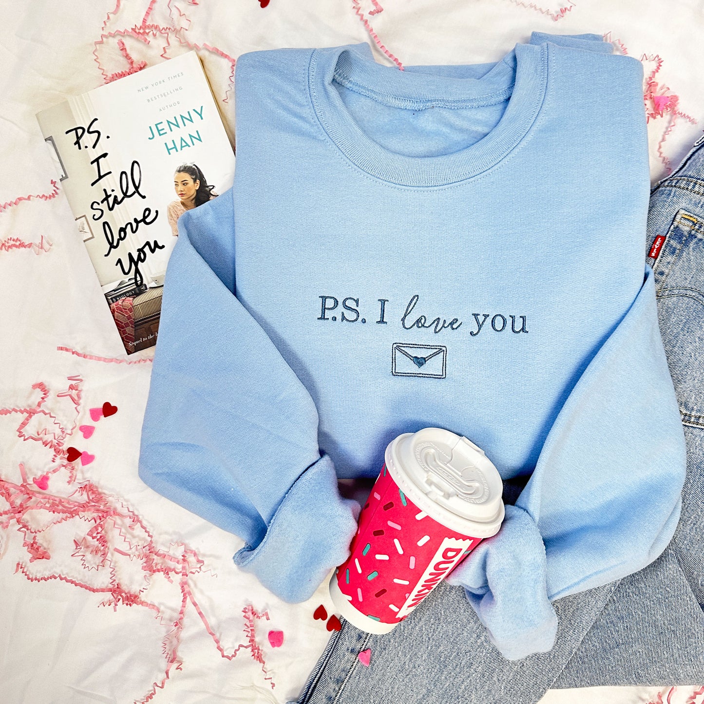 light blue crewneck sweatshirt with a custom embroidery design that says P.S. I love you  in  a French Blue thread.