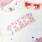 close  up of a TEACH printed design on a white t-shirt with a watercolor heart fill pattern